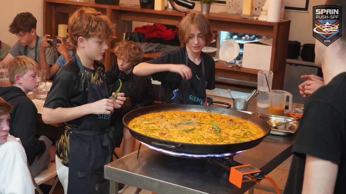 Players enjoying a paella cooking show